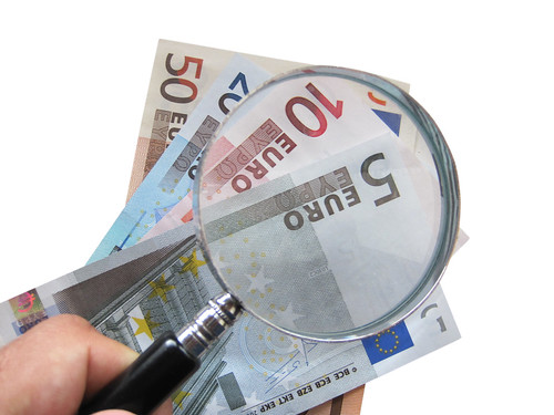 banknoty euro pod lupą - oszczędności zdjęcie