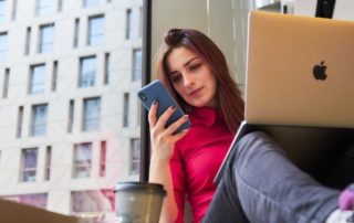dziewczyna z laptopem i telefonem z instagramem w ręku zdjęcie